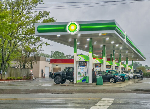 Charleston, South Carolina - April 7, 2018: BP gas station at night with green colors and cars refueling.