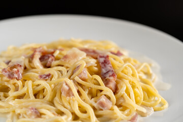 carbonara spaghetti with cream in white plate on balck backgroud