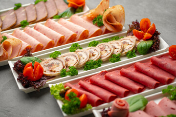 Platter of fresh meat cold cuts with vegetables.