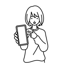 立ってスマートフォンを指差してこちらに向けて見せているリモートワークの女性