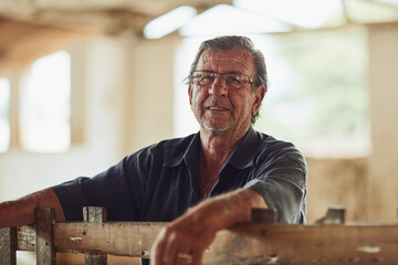 This farm belongs to him. Portrait of a male farmer inside a barn.