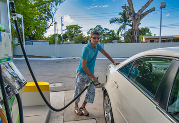 Happy man refueling car at self service gas station.