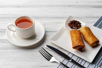 Russian pancakes with filling lying on a plate on table