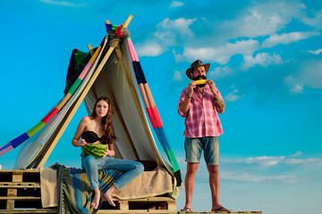 Hikers hipsters couple camping in tent on nature. Romantic lovers on vacation camping. Breakfast with lovers on nature. Organic food.