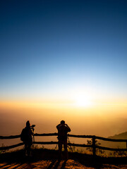 Fototapeta na wymiar Silhouette Tourists Taking Pictures of The Sunrise