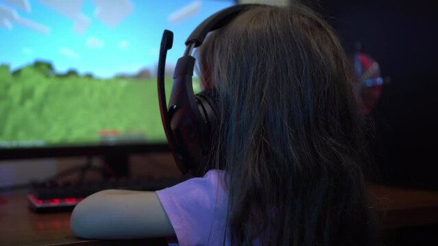 A child with headphones plays an online video game on the computer. The problem of Computer Game Addiction in Children. . Entertainment during the lockdown