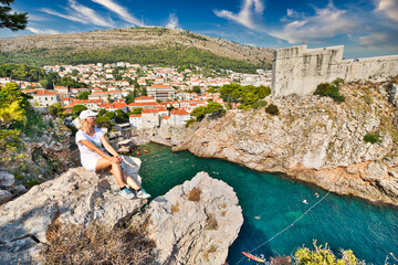 Dubrovnik cityscape with Fort Bokar in Croatia of Dalmatia. UNESCO Venetian architecture. Woman on top of Lovrijenac fortress, over the West Harbour of Dubrovnik city of Croatia.