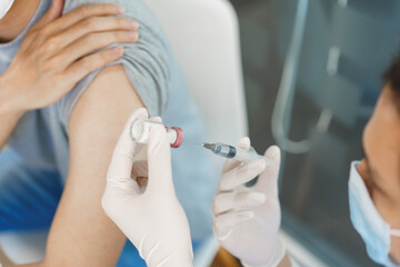 Vaccination concept, Male doctor preparing vaccine against covid-19 to injecting for male patient