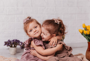 two little girls in beautifull  dresses  at the studio with flowers