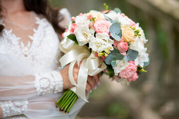 wedding bouquet large in the hands of the bride. dercore of roses