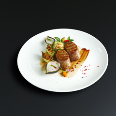 traditional dishes of European cuisine, delicacy, banquet snack. culinary dishes on a white plate on a black background. restaurant service