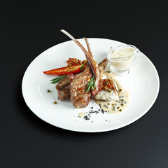 traditional dishes of European cuisine, delicacy, banquet snack. culinary dishes on a white plate on a black background. restaurant service