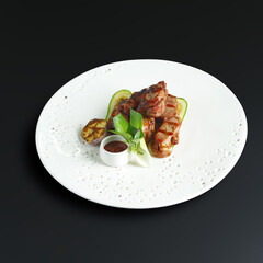 traditional dishes of European cuisine, delicacy, banquet snack. culinary dishes on a white plate on a black background. restaurant service