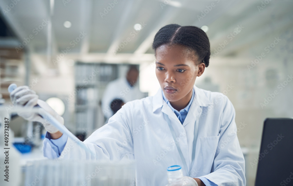 Poster Preparing some samples for a new trial. Shot of a young scientist working in a lab.