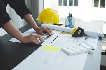 Architects or engineers working construction and drawing construction plans, printing, writing on-site construction sites. Home design concept