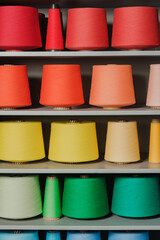 Shelf, rack with yarn coils, threads of different colors. Knitting accessories. Concept for needlework. Weaving Factory. Clothing brand. Yarn and thread. Product range. Seamstress, tailor, cutter.
