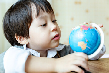 Happy asian little boy on bed.