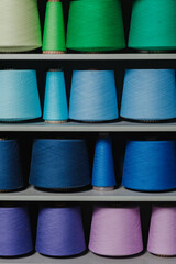 Shelf, rack with yarn coils, threads of different colors. Knitting accessories. Concept for needlework. Weaving Factory. Clothing brand. Yarn and thread. Product range. Seamstress, tailor, cutter.