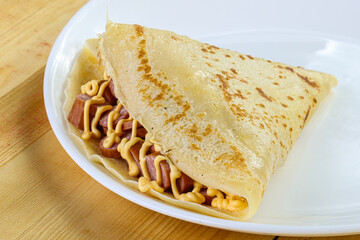 Pancake with sliced sausage and mustard