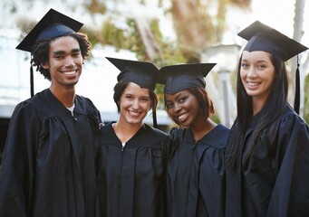 Theyve got a bright future ahead. A group of smiling college graduates standing together in cap and...