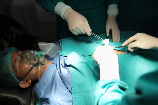 Closeup image of professional concentrated surgical team hands performing an operation with patient in hospital operating room. Surgery concept.