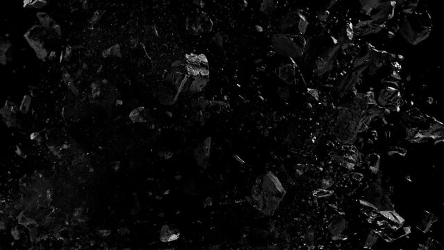 Super slow motion of rotating coal pieces on black background. Filmed on high speed cinema camera, 1000fps. Speed ramp effect.