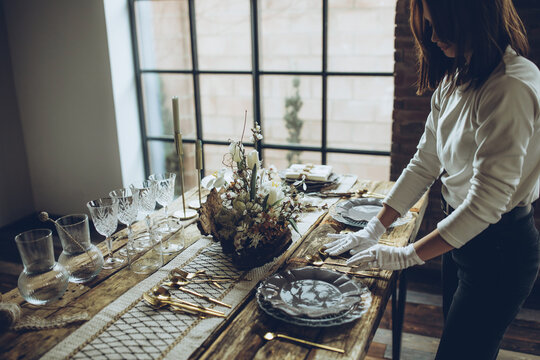 Table setting. A woman decorates the table for the holiday. High quality photo