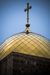 Fototapeta na wymiar Golden-topped dome and cross in the old city of Jerusalem in Israel