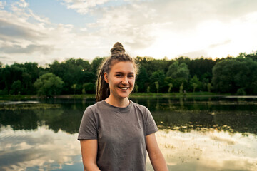Portait of smiling woman in park, lake background.