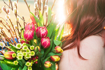 Eine Junge Frau hält einen schönen Strauß Frühlingsblumen. 