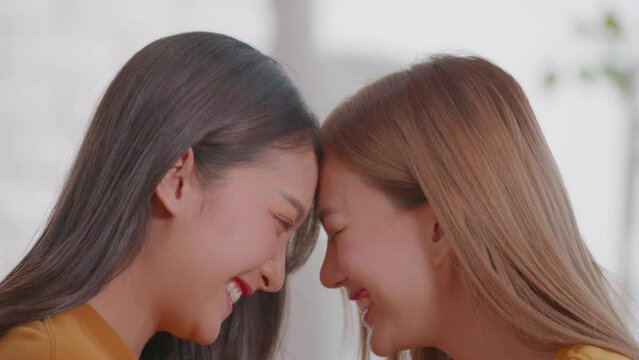 Young Asian women couple is teasing each other. They are the cutest LGBT couple wearing a couples t-shirt and giggles together. They spend time together as a normal couples and LGBT conceptual.