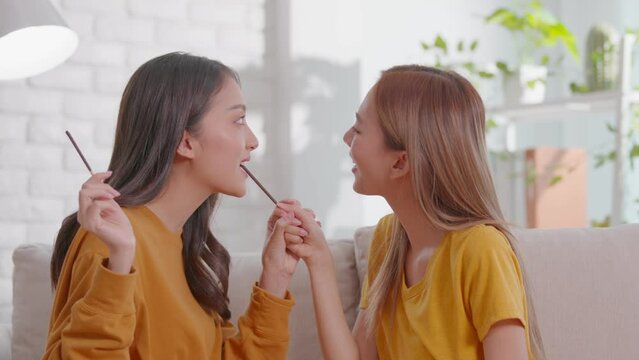 An Asian lesbian is spending time together as a normal couples and LGBT conceptual are. They feed some snacks to each other and also giggles together all the time.