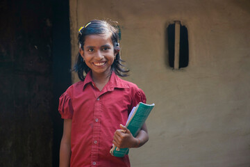 rural girl holding books ready for school. India