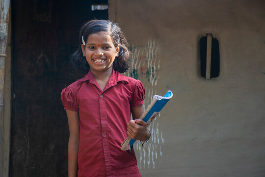 Rural Girl Holding Books Ready For School. India