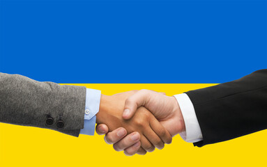 political, business and national concept - close up of handshake over colors of flag of ukraine on background