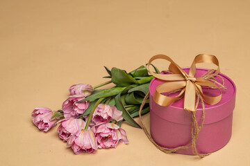 a lilac gift box and a bouquet of pink tulips