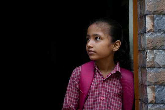school girl standing at the door with her bag