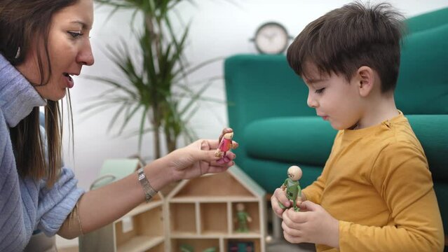 Children therapy with games. Young female therapist playing with toy to help autist child to improve his behavior and mental health