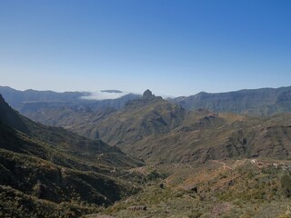 Fototapeta na wymiar Roque (roca) Bentayga y Barranco del Chorrillo de la carretera GC-60 en Tejeda, Gran Canaria, España (26 04 2018). Típico paisaje agreste.
