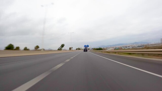 driving a car on the barcelona motorway highway in spain, fast camera mounted on the front time lapse with motion blur