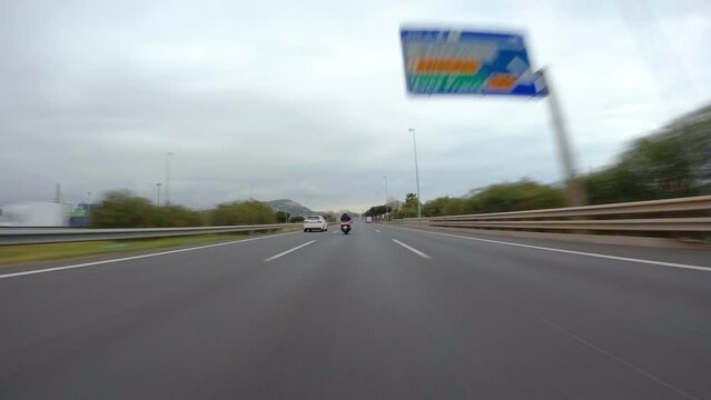 driving a car on the barcelona motorway highway in spain, fast camera mounted on the front cloudy day