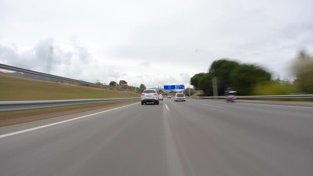 driving a car on the barcelona motorway highway in spain, fast camera mounted on the front time lapse with motion blur cloudy day