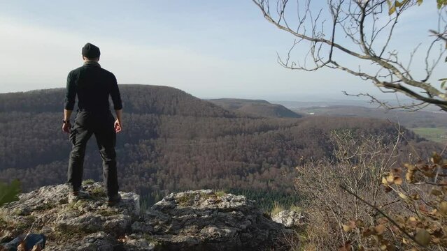 Panoramic view behind a Man walking towards a cliff in Slow Motion