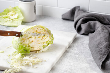 Preparing cabbage, shredded cabbage. Chop cabbage on white board with knife and napkin