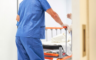 Krankenpfleger schiebt Krankenbett mit Patient im Krankenhaus