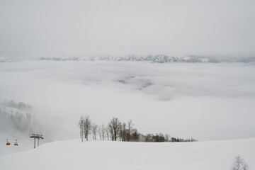 Part of the lift up the mountain, winter cloudy day with fog.