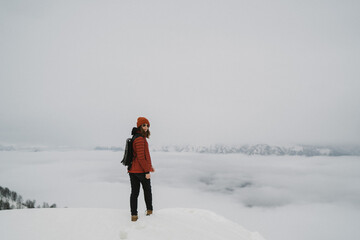 Woman standing in mountain. Cold weather, snow on hills. Winter hiking.