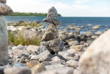 Fototapeta na wymiar nature, harmony and balance - close up of stone pyramids or towers on beach
