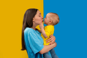 YOUNG MOTHER WITH HER CHILD IN THE COLORS OF UKRAINE - 492758335