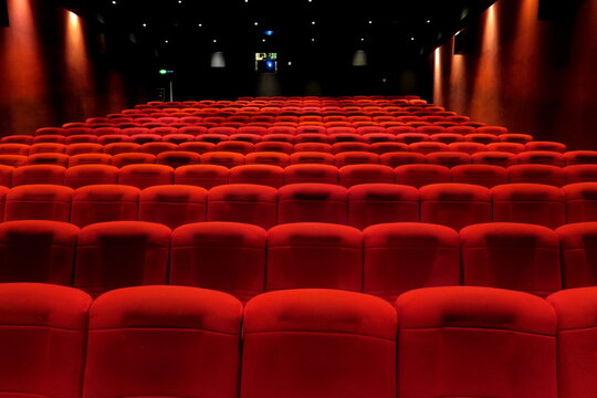 Salle de cin&eacute;ma vide. Rang&eacute;es de fauteuils de velours rouge.